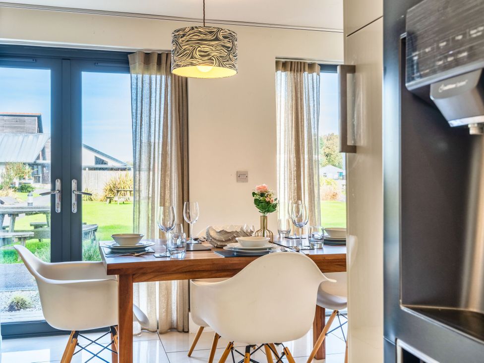 A dining room with a table and chairs at Chapel Park in Marhamchurch