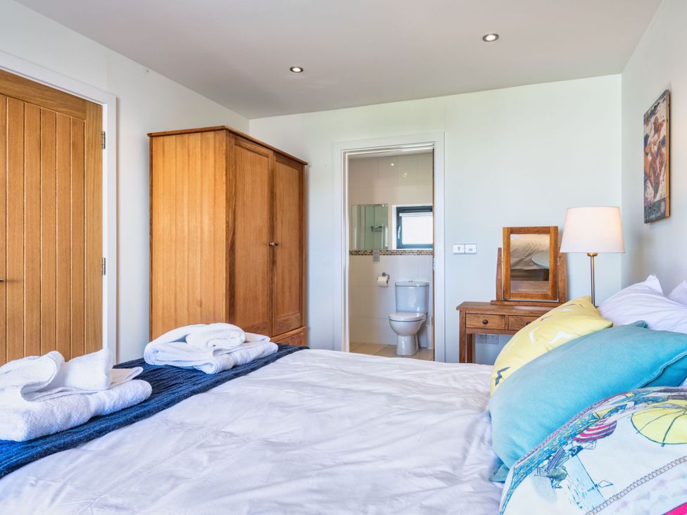 A bedroom with a bed and wardrobe at Chapel Park in Marhamchurch