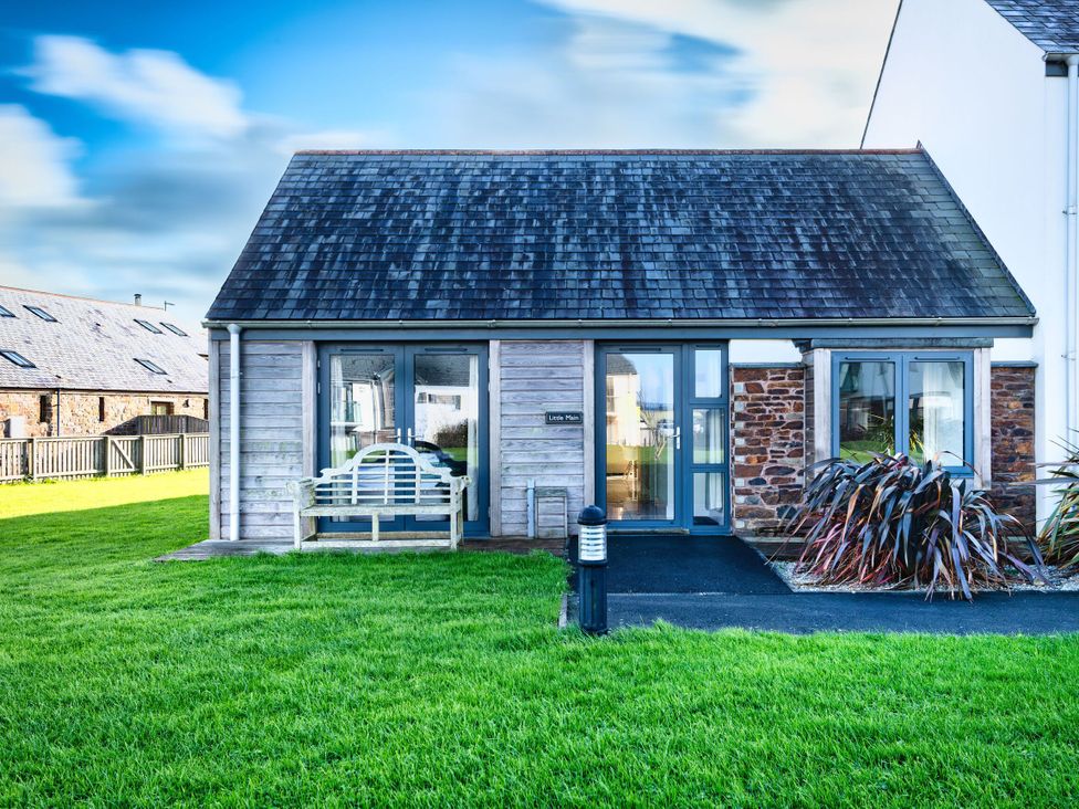 A wooden house with a slate roof and a garden at Little Main in Marhamchurch