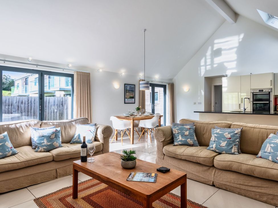 A living room with sofa and dining area at Little Main in Marhamchurch