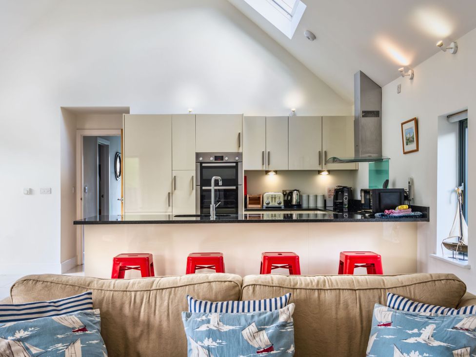 A kitchen with cabinets and appliances at Little Main in Marhamchurch