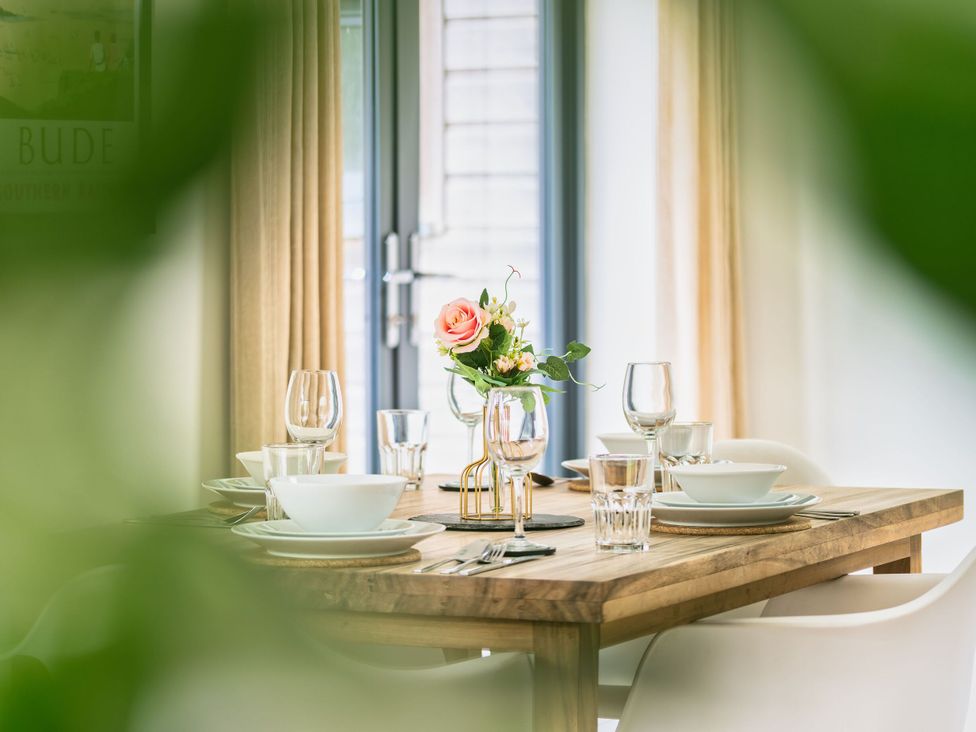 A dining room table set with tableware at Little Main in Marhamchurch