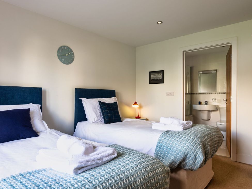 A bedroom with two beds and access to a bathroom at Little Main in Marhamchurch