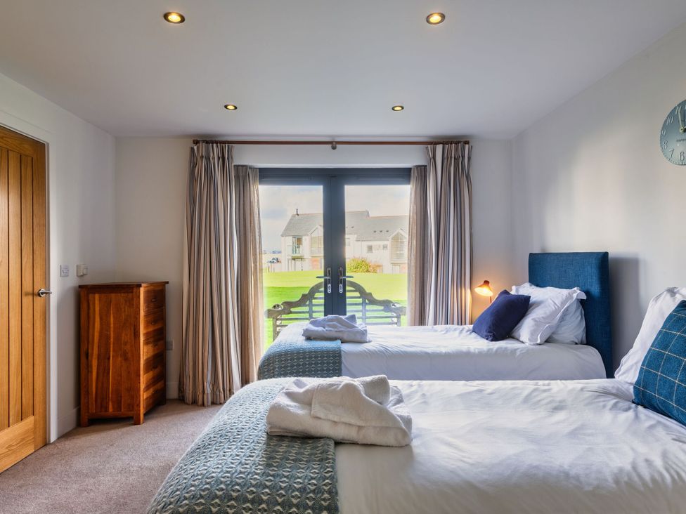 A bedroom with two beds and a chest of drawers at Little Main in Marhamchurch
