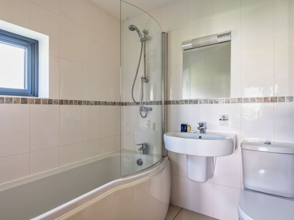 A bathroom with a bathtub, shower, sink, and toilet at Little Main in Marhamchurch