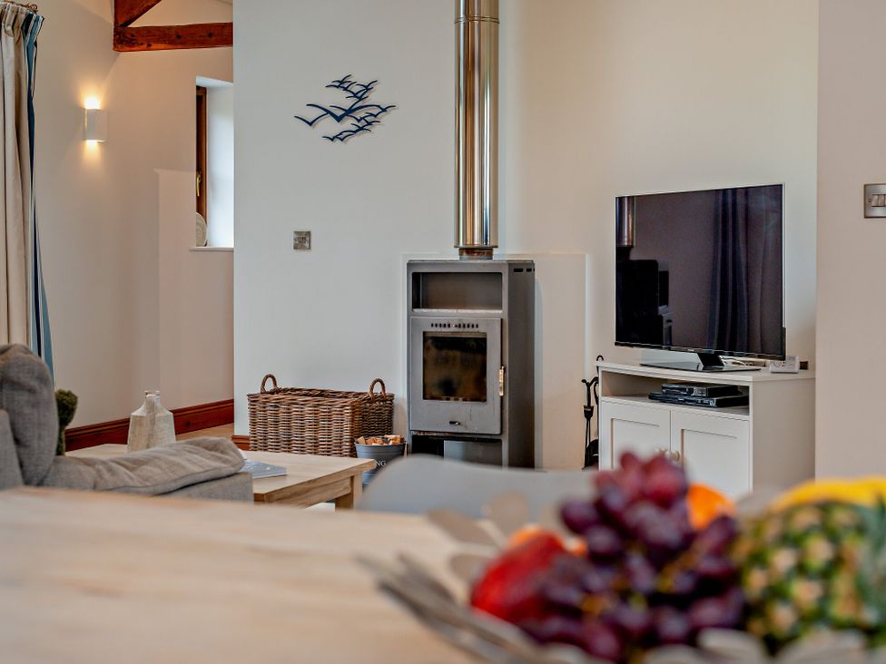 A living room with a sofa and television at Long Down Spa in Marhamchurch