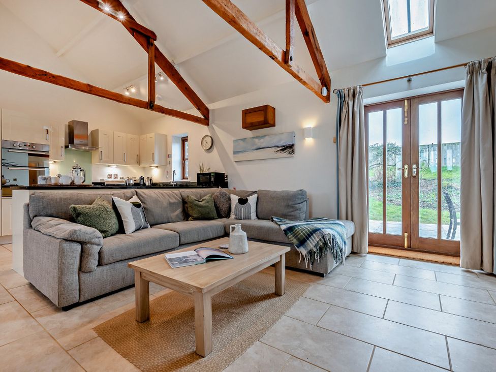 A living room with a sofa and coffee table at Long Down Spa in Marhamchurch