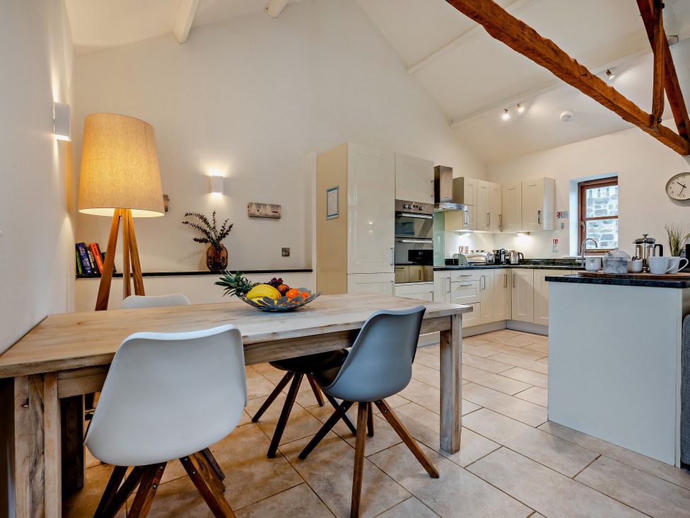 A kitchen with a dining table and chairs at Long Down Spa in Marhamchurch