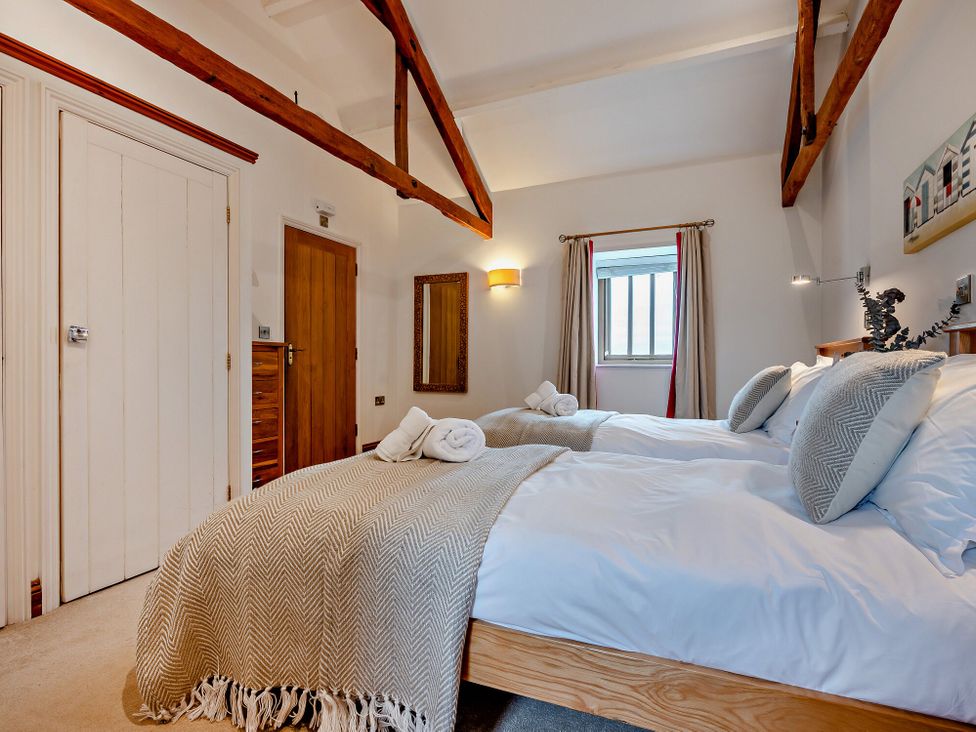 A bedroom with twin beds and a window at Long Down Spa in Marhamchurch