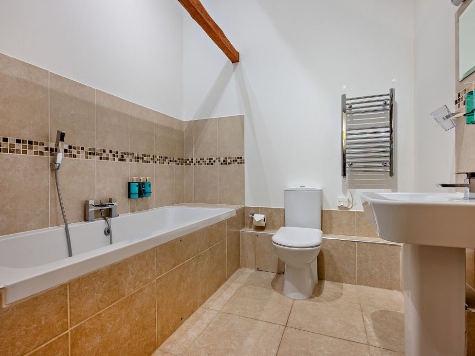 A bathroom with bathtub sink and toilet at Long Down Spa Marhamchurch