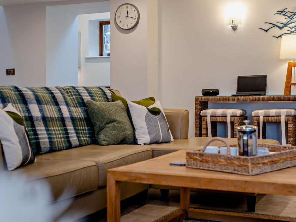 A living room with a sofa and table at Middle Hill in Marhamchurch