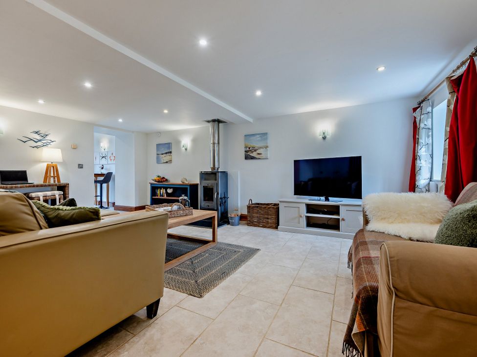 A living room with a sofa coffee table and television at Middle Hill in Marhamchurch