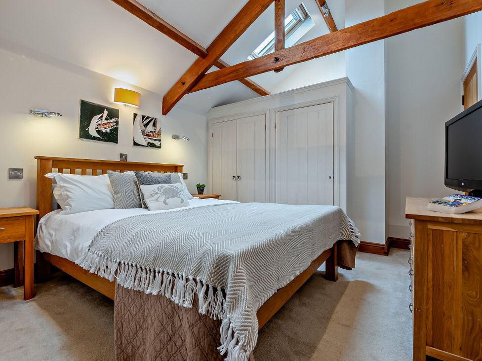 A bedroom with a bed and nightstands at Middle Hill in Marhamchurch