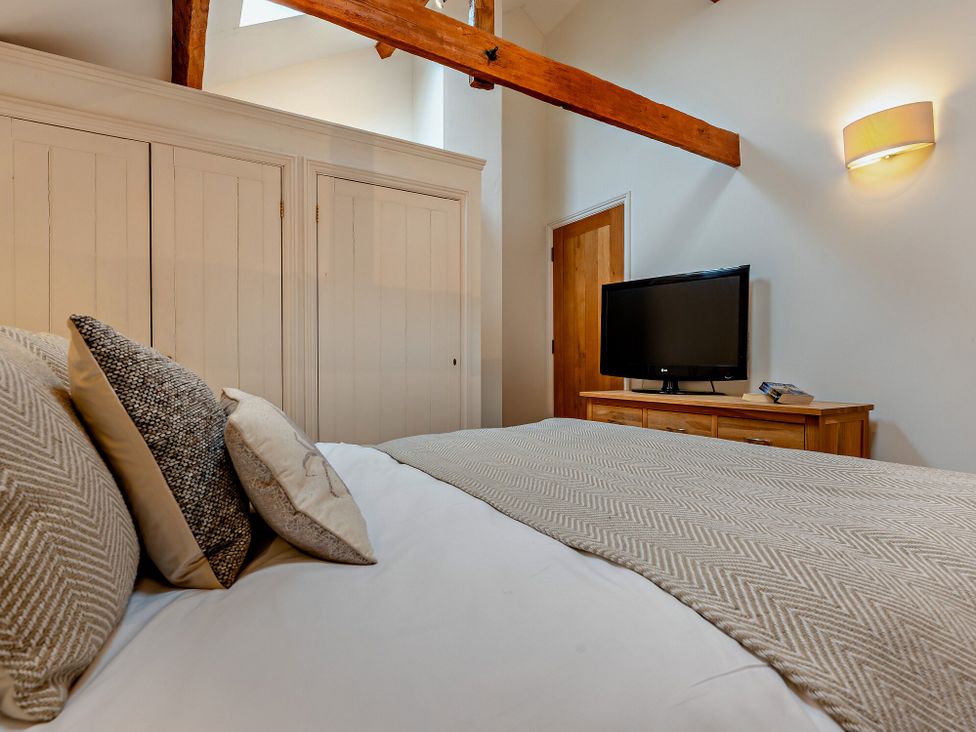 A bedroom with a bed and television at Middle Hill in Marhamchurch