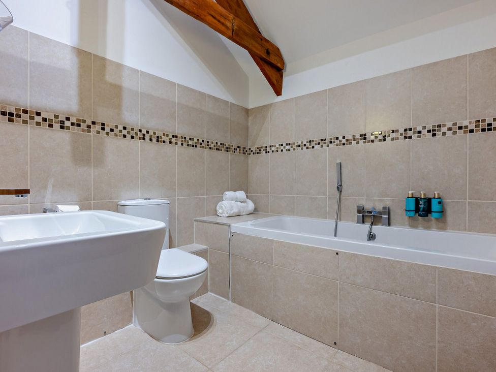 A bathroom with a bathtub, toilet, and sink at Middle Hill in Marhamchurch