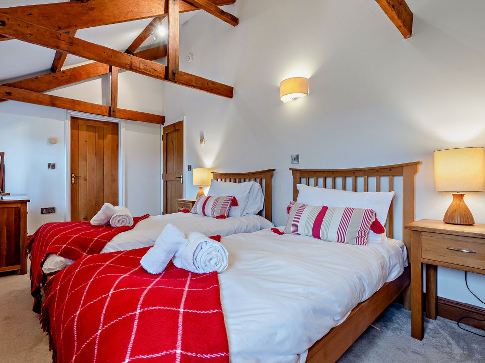 A bedroom with twin beds and wooden furniture at Middle Hill in Marhamchurch