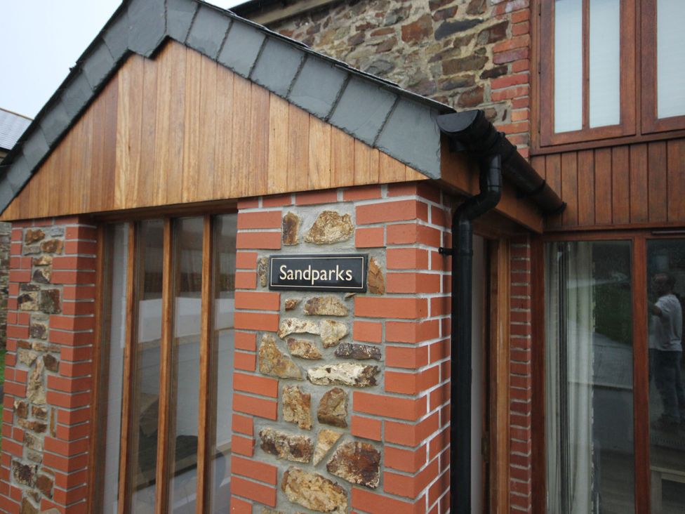 An exterior view of a building with a sign at Sand Parks in Marhamchurch