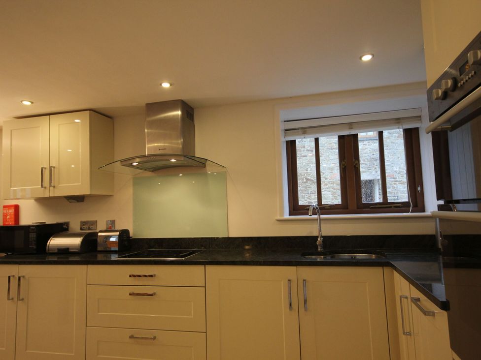 A kitchen with cabinets and appliances at Sand Parks in Marhamchurch
