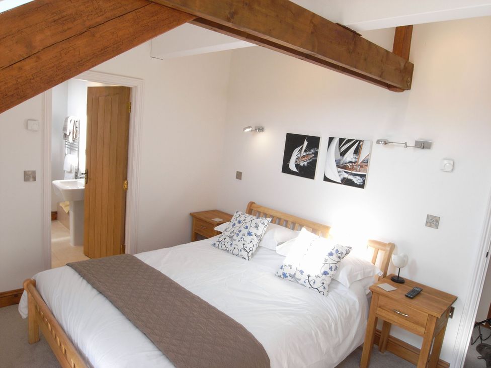 A bedroom with a bed and nightstand at Sand Parks in Marhamchurch