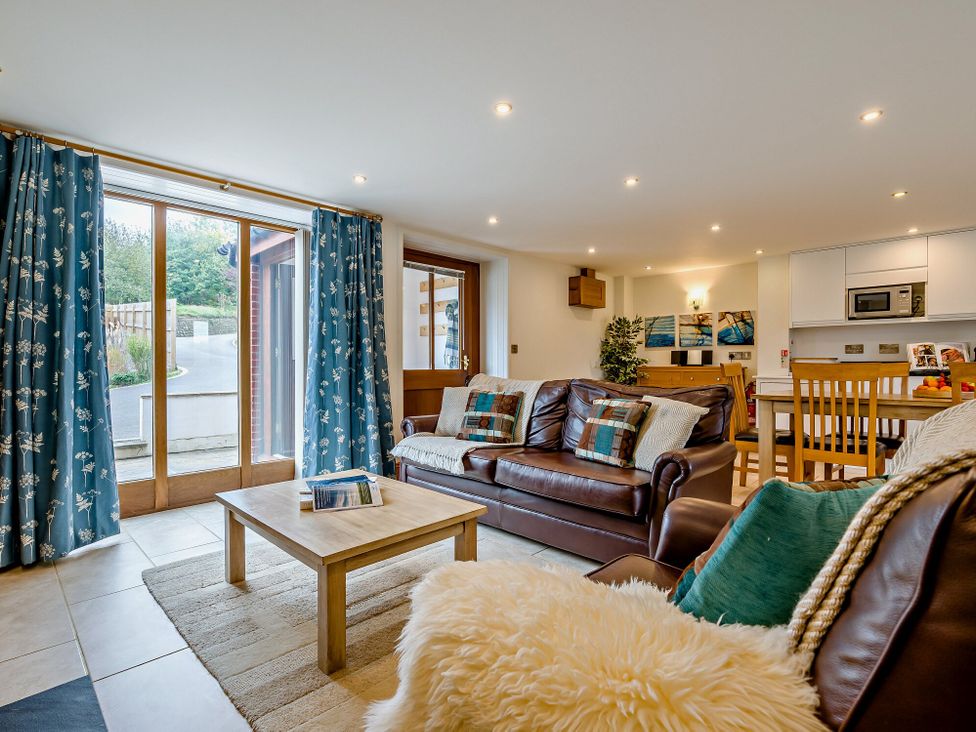 A living room with a sofa and coffee table at Sand Parks in Marhamchurch