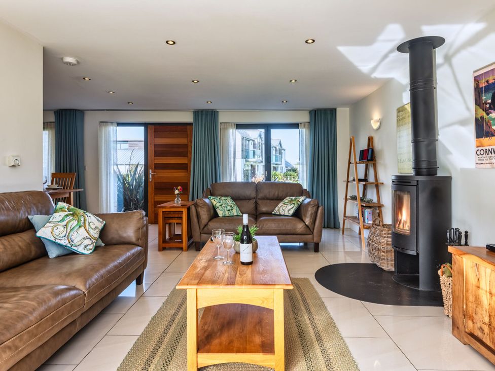 A living room with a fireplace and seating at Venners in Marhamchurch