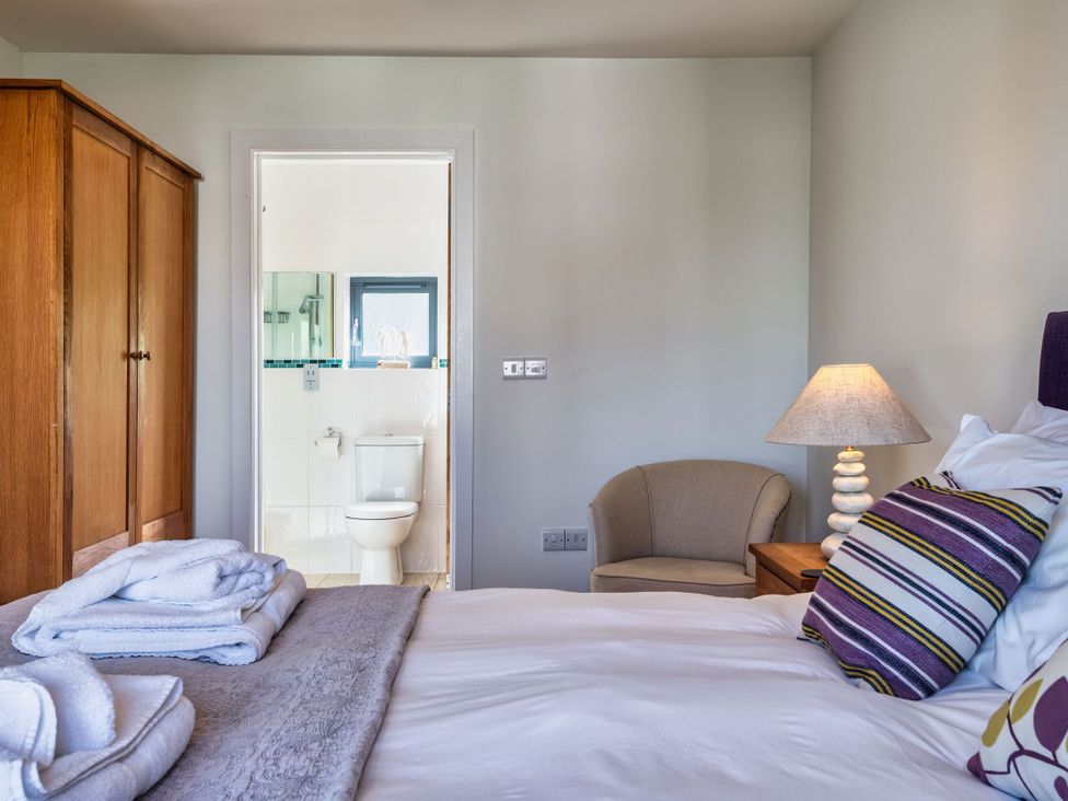 A bedroom with wardrobe and bathroom visible at Venners in Marhamchurch