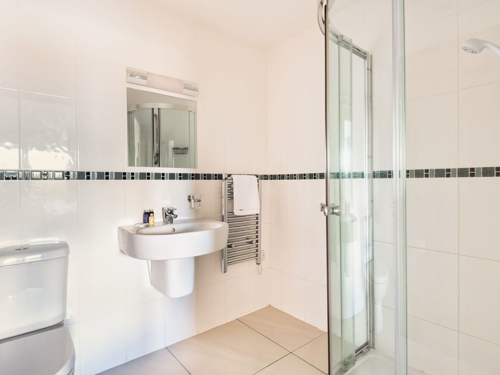 A bathroom with a sink and shower at Warrens Spa in Marhamchurch