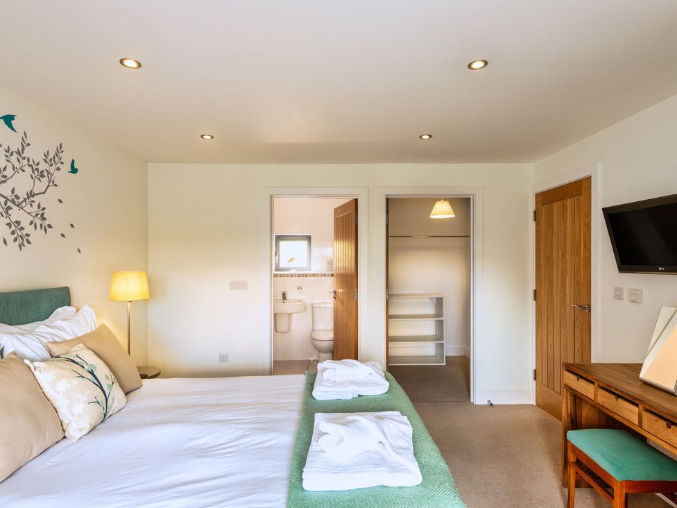 A bedroom with a bed and wardrobe at Warrens Spa Marhamchurch