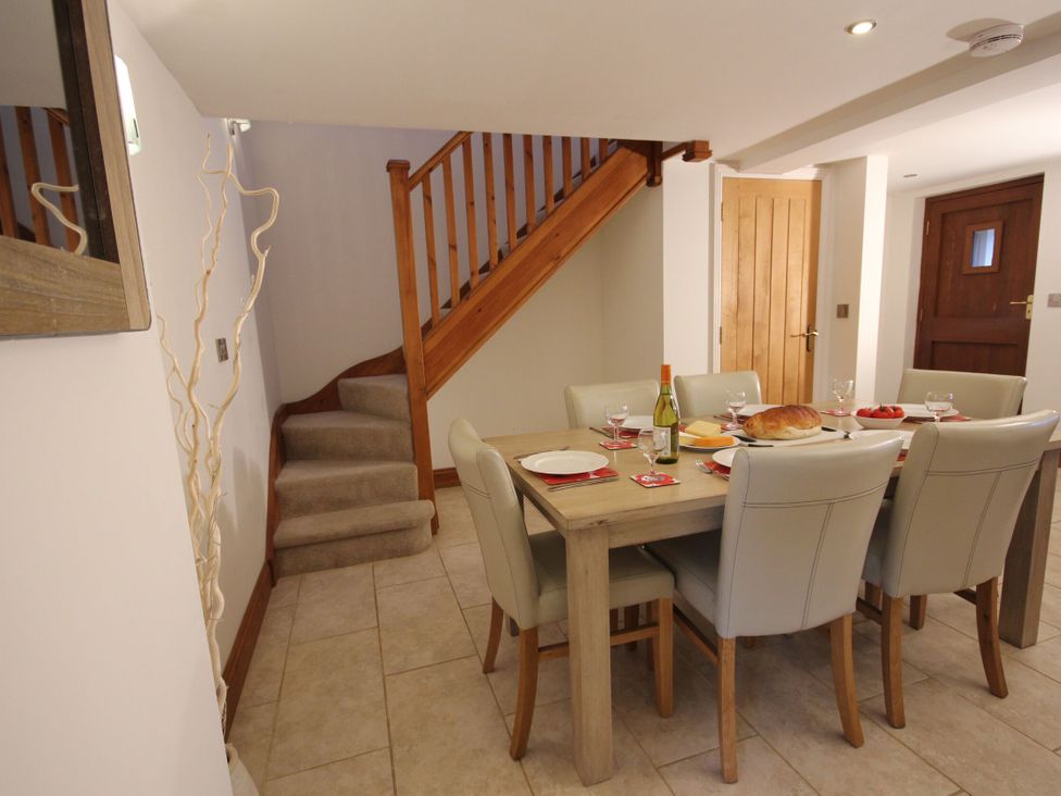 A dining room with a table set for a meal at Westcotts in Marhamchurch