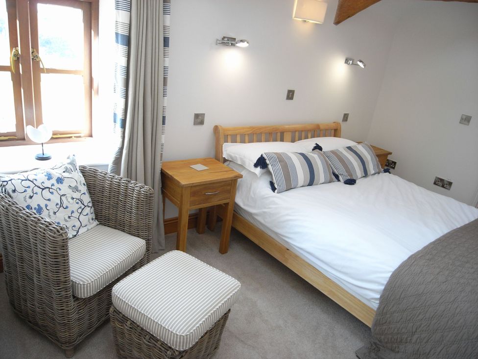 A bedroom with a bed and chairs at Westcotts in Marhamchurch