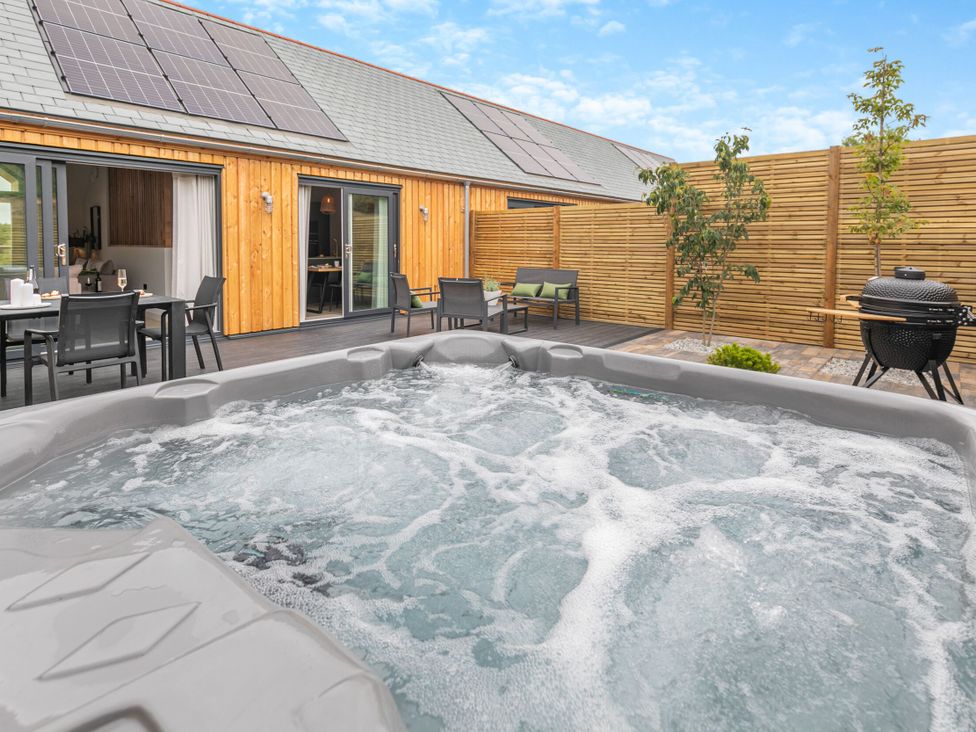 A hot tub in an outdoor space at Gwari Spa Barn 2.0 Marhamchurch