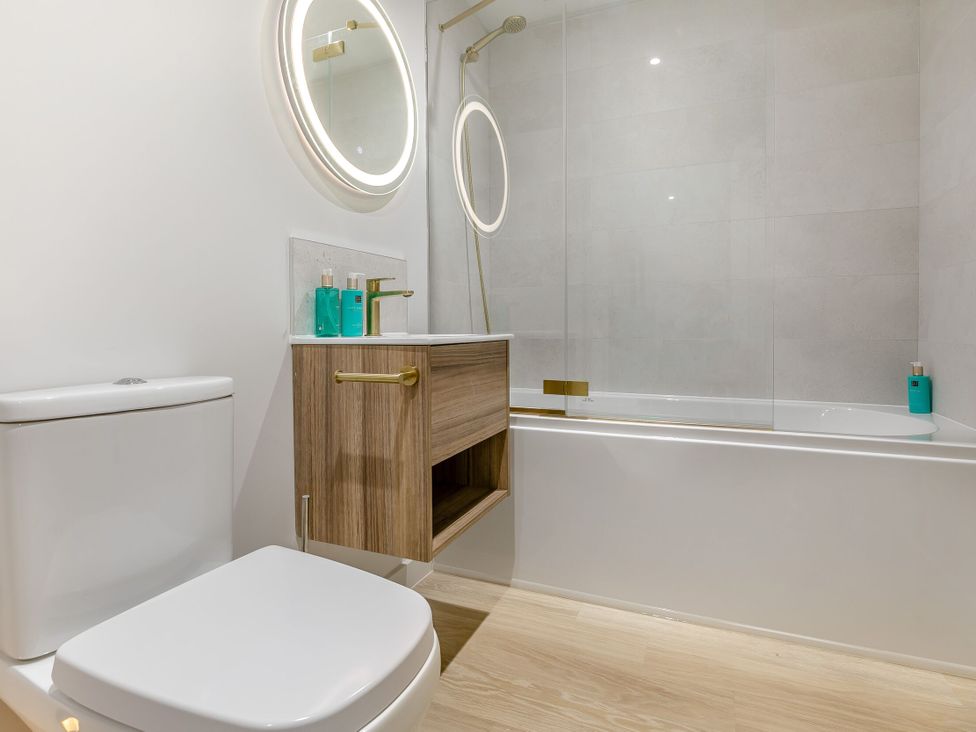 A bathroom with a toilet, bathtub, and a sink at Gwari Spa Barn 2.0 in Marhamchurch