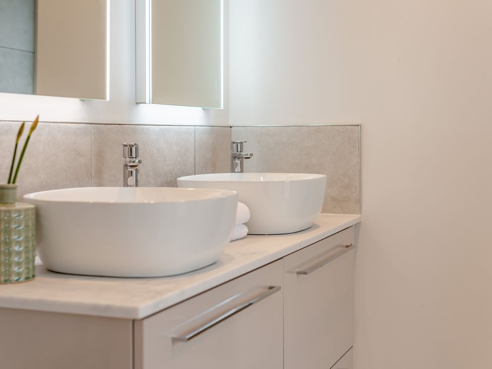 A bathroom with bowl sinks and mirrors at Trelowen 2.0 Spa in Marhamchurch