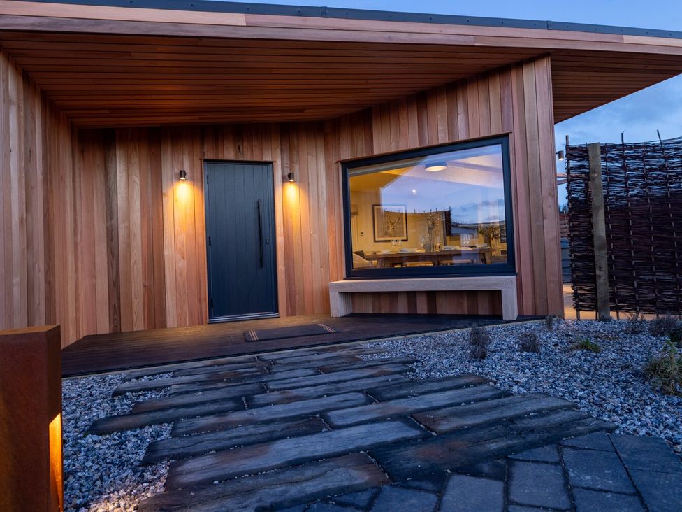 An outdoor entrance with a wooden door and window at Trelowen 2.0 Spa Marhamchurch