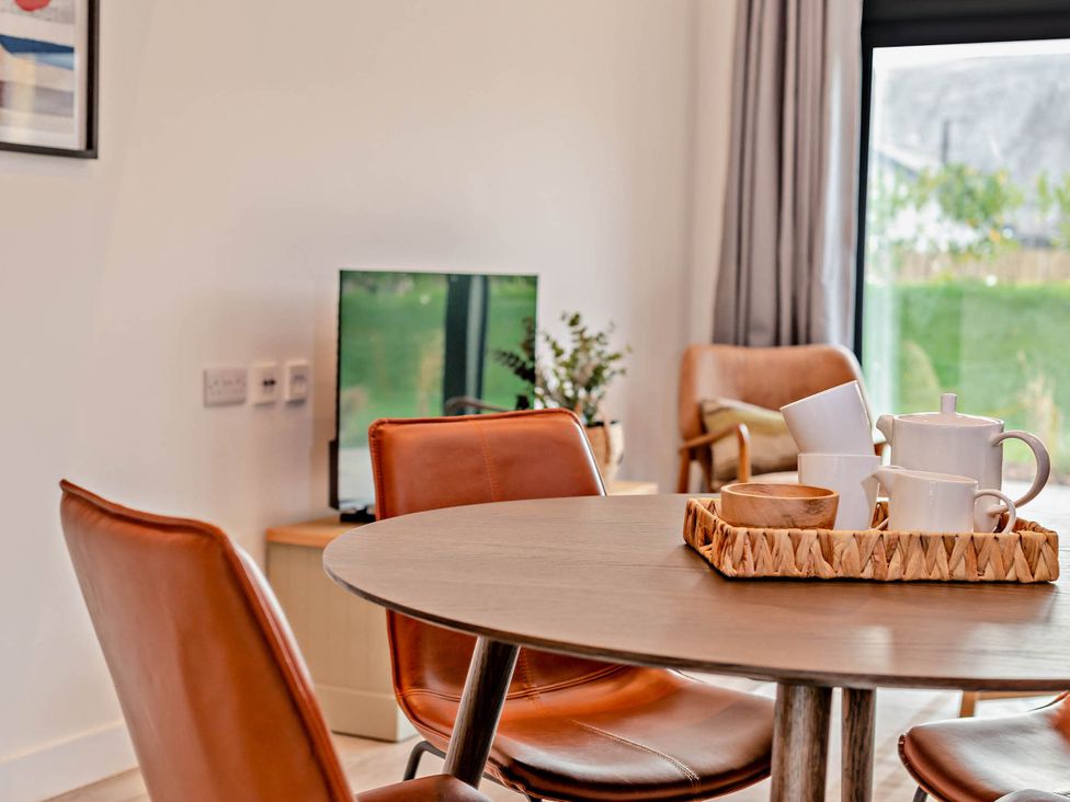 A dining room with a table and chairs at Arvor Duplex 2.0 in Marhamchurch