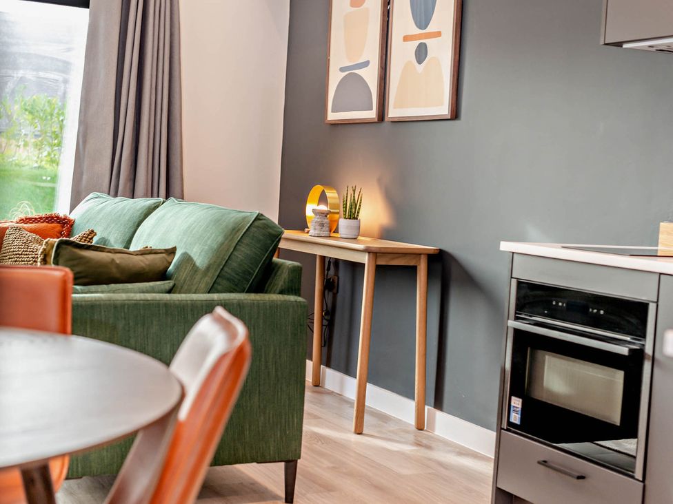 A living room with a sofa and table at Arvor Duplex 2.0 in Marhamchurch