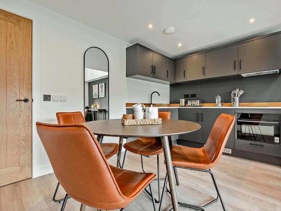 A dining room with a table and chairs at Arvor Duplex 2.0 in Marhamchurch