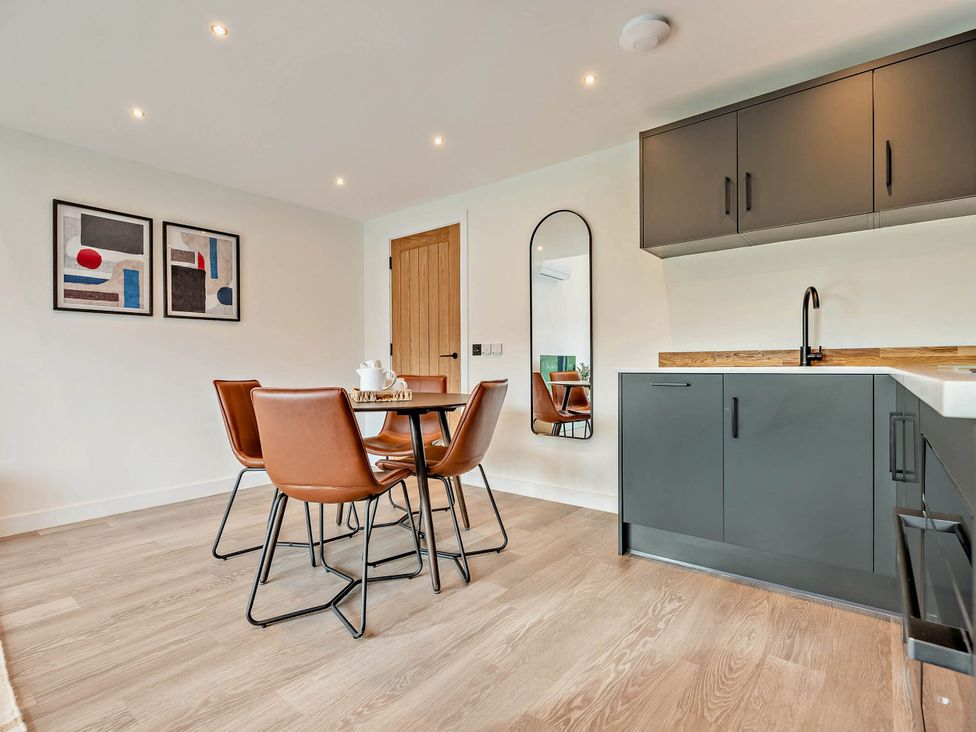 A dining room with a table and chairs at Arvor Duplex 2.0 in Marhamchurch