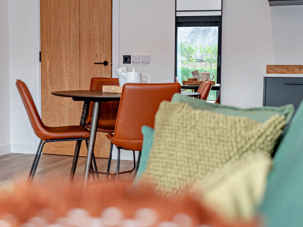 A dining room with a table and chairs at Arvor Duplex 2.0 in Marhamchurch