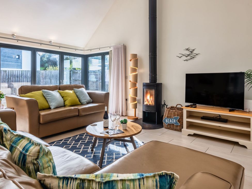 A living room with a sofa, coffee table, and fireplace at Nettlecoombe Spa in Marhamchurch