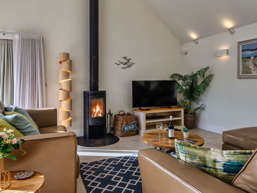 A living room with a fireplace and sofa at Nettlecoombe Spa in Marhamchurch