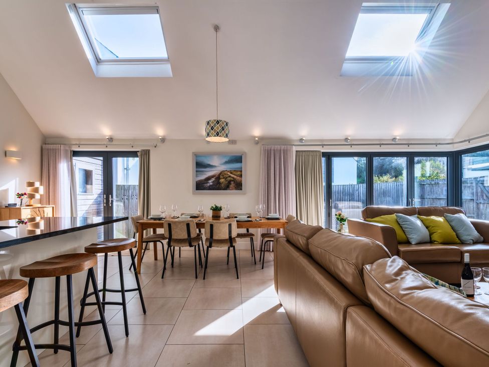 A living room with a sofa and dining table at Nettlecoombe Spa in Marhamchurch