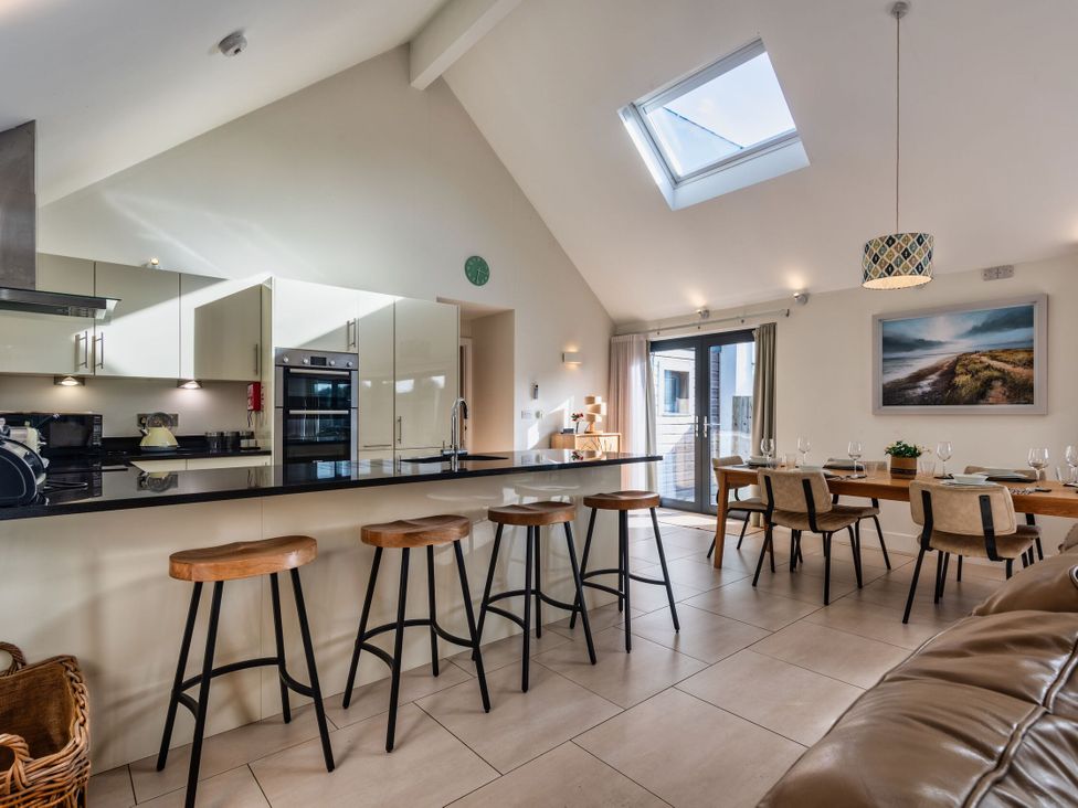 A kitchen and dining area with a table and chairs at Nettlecoombe Spa in Marhamchurch