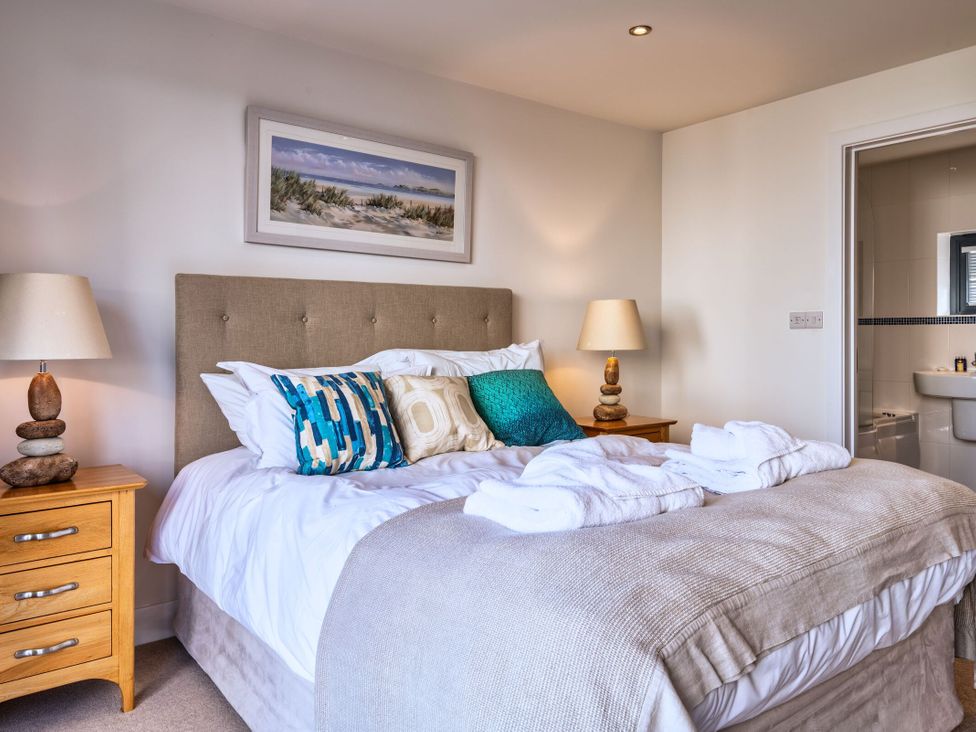 A bedroom with a bed and bedside table at Nettlecoombe Spa in Marhamchurch