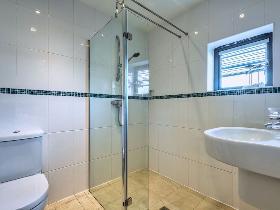 A bathroom with a shower, toilet, and sink at Nettlecoombe Spa in Marhamchurch