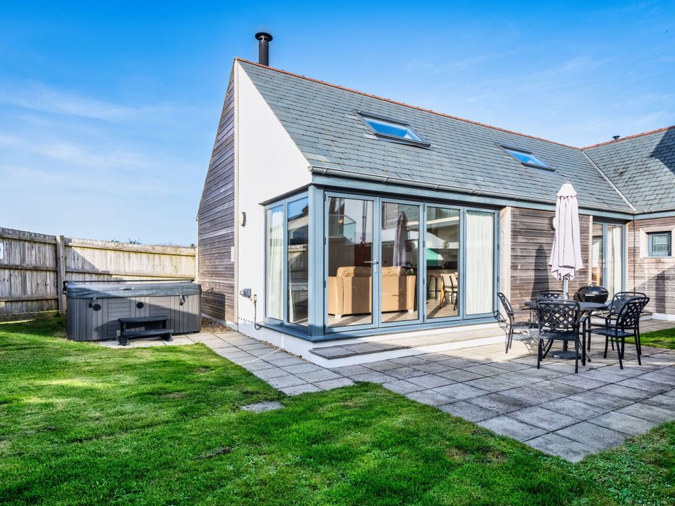 An outdoor area with a hot tub and seating at Nettlecoombe Spa in Marhamchurch