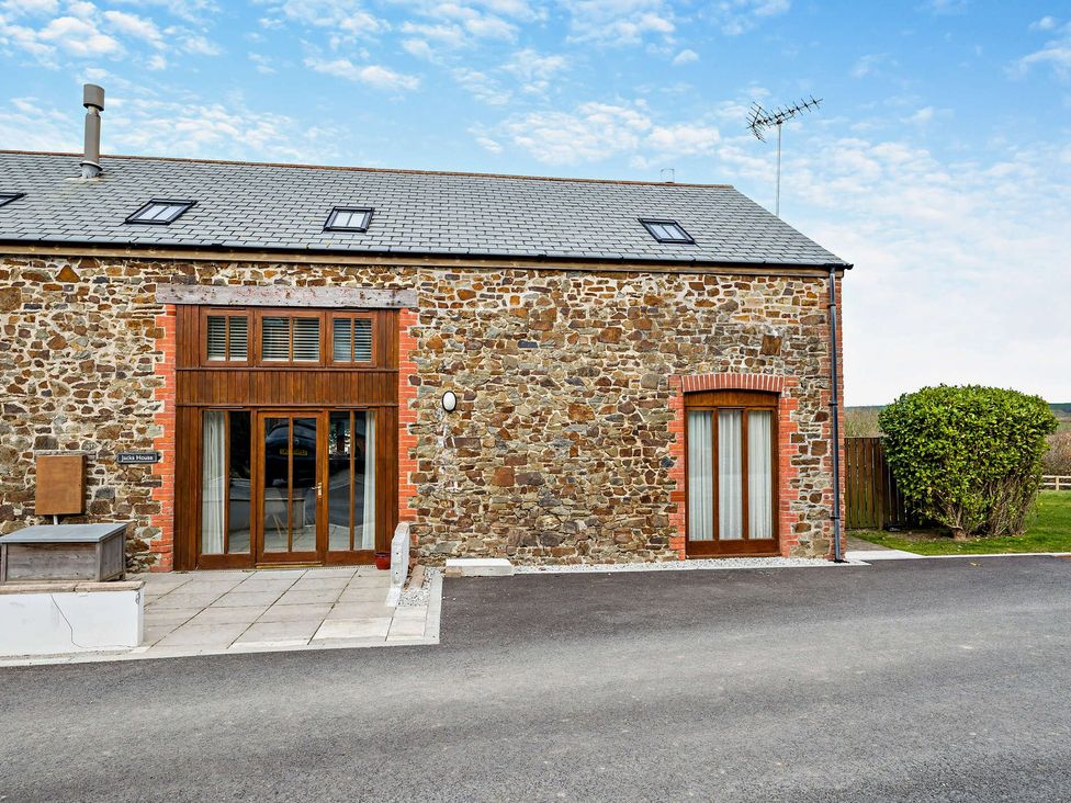 A stone building with windows and doors at Jack's House in Marhamchurch