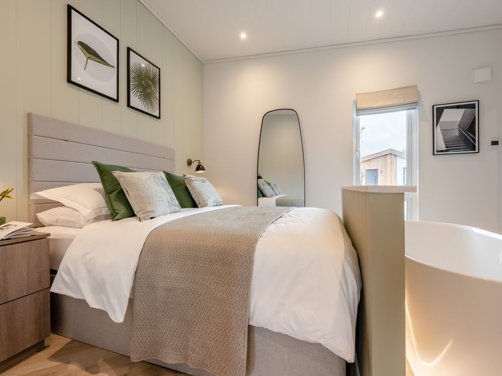 A bedroom with a bed and a bathtub at Trelowen 4.0 Spa in Marhamchurch