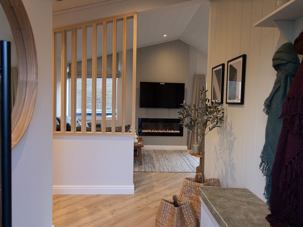 A living room with a television and fireplace at Trelowen 4.0 Spa in Marhamchurch