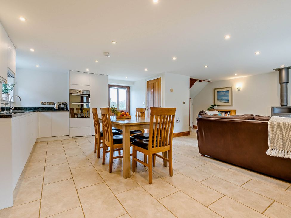 A kitchen with dining table and chairs at Trelowen 4.0 Spa in Marhamchurch
